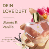 Perfume bottle with flowers and vanilla beans on a pink background