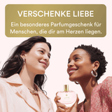 Two women holding a perfume bottle with a text overlay about giving love as a special gift.