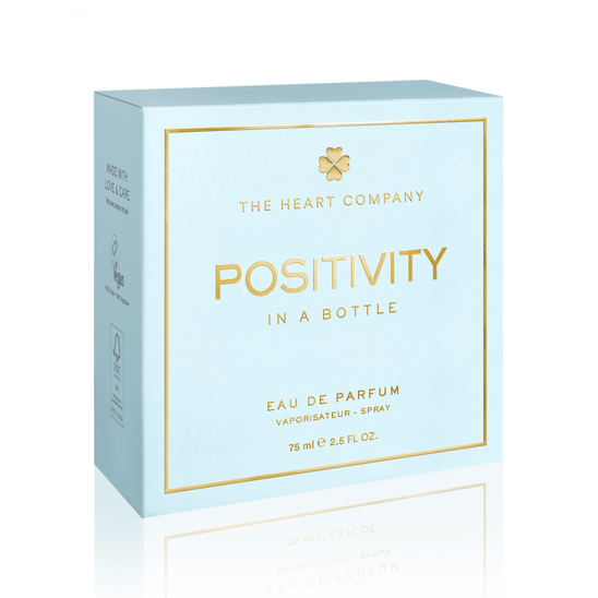 Positivity in a Bottle vegan eau de parfum box by The Heart Company in soft light blue with gold details, representing a fresh, aquatic, clean fragrance that is paraben-free and phthalate-free, designed to uplift mood, inspire positivity, and support everyday wellness