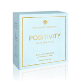 Positivity in a Bottle vegan eau de parfum box by The Heart Company in soft light blue with gold details, representing a fresh, aquatic, clean fragrance that is paraben-free and phthalate-free, designed to uplift mood, inspire positivity, and support everyday wellness