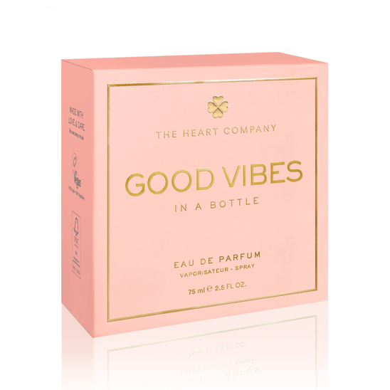 Vegan “Good Vibes in a Bottle” eau de parfum packaging by The Heart Company, featuring a soft pink luxury box with gold lettering, a fruity, floral, sweet gourmand fragrance, cruelty-free perfume designed to uplift mood and spread positive energy.