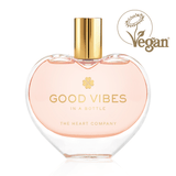 Vegan “Good Vibes in a Bottle” eau de parfum in a heart-shaped glass bottle with gold cap, featuring a fruity, floral, sweet gourmand fragrance, cruelty-free luxury perfume designed to uplift mood and deliver positive energy