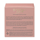Back view of “Good Vibes in a Bottle” vegan eau de parfum packaging by The Heart Company, featuring product description, ingredients, and safety information. Fruity, floral, sweet gourmand perfume designed to uplift mood, presented in elegant rose-pink box, cruelty-free and made in the USA.